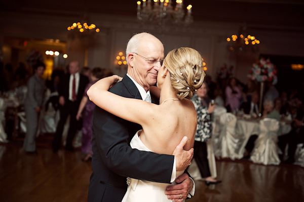 bride and father of the bride dancing at reception - bride is wearing hair in a low bun with white hair accessories - photo by Houston based wedding photographer Adam Nyholt